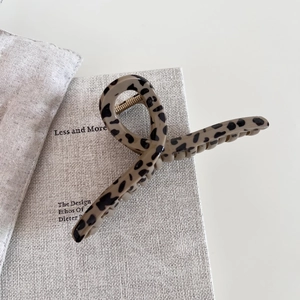 Detail view of large leopard print hair claw clip on textured background
