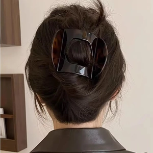 Detail of tortoise shell hair claw clip styled on a woman's back hair bun