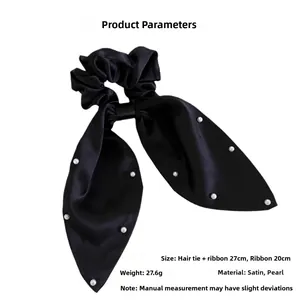 Detail of black satin scrunchie with long bow ribbons and white pearls decoration