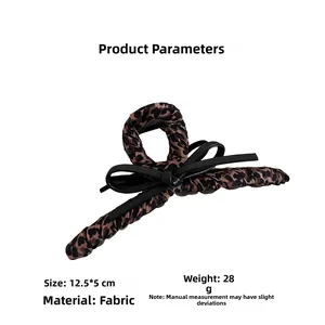 Detail view of leopard print bow hair claw clip measuring 12.5x5cm made of soft fabric