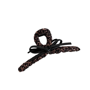 Retro leopard print hair claw clip with black bow accent on a clean white background