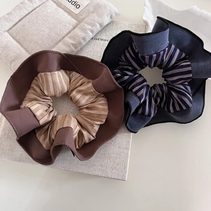Detailed macro view of striped fabric scrunchies with elegant double-layered ruffled edges