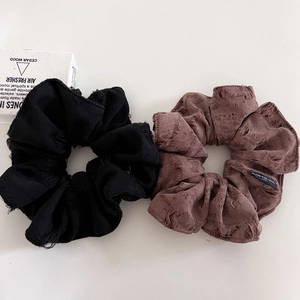Brown and black oversized scrunchies with vintage texture and Blind For Love label