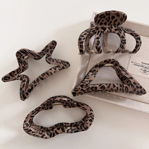 Four leopard print hair claws in star, triangle and wave shapes for elegant styling