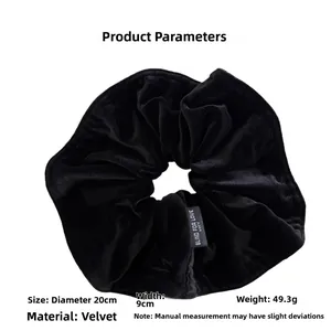 Detail view of large black velvet hair scrunchie with 20cm diameter and fabric tag