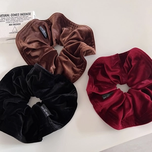 Three-piece set of velvet scrunchies in brown, black, and burgundy with vintage labels