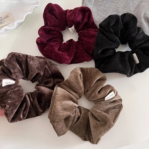 Flat lay of vintage velvet scrunchies in burgundy and brown with Hand Made labels