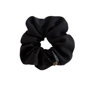 Retro black polka dot scrunchie with Lucky gold charm and elegant fabric texture