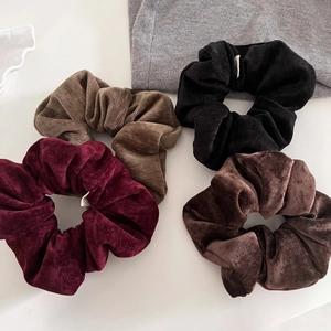 Set of four oversized velvet scrunchies in autumn retro colors like burgundy and coffee
