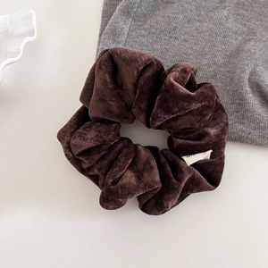 Close-up of brown velvet scrunchie showing soft texture and premium Made brand label