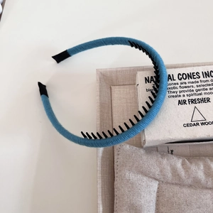 Detail view of the light blue woven headband with non-slip teeth and comfortable fabric ends