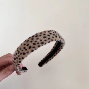 Vue détaillée du serre-tête léopard montrant la texture douce en peluche et la doublure