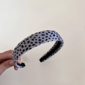 Détail d'un serre-tête en velours léopard avec doublure intérieure noire antidérapante