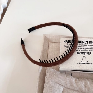 Detail view of the brown yarn-wrapped headband showing anti-slip inner plastic teeth