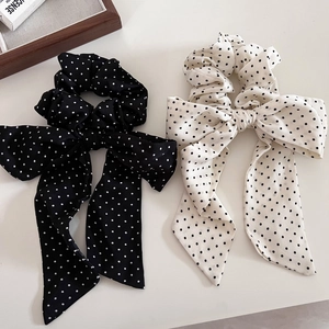 Dettaglio di elastici per capelli in chiffon a pois con lunghi nastri in nero e bianco
