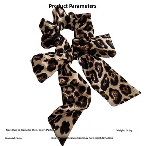 Macro shot of 18x22cm satin leopard print bow scrunchie with detailed fabric texture