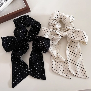 Dettaglio degli elastici per capelli con fiocco a pois in chiffon bianco e nero