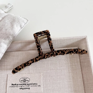 Elegant large leopard print hair claw clip with vintage fabric wrap on textured tray