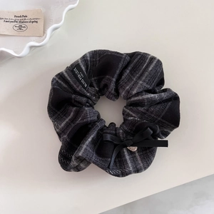 Detailed shot of retro plaid hair scrunchie with heart pendant and bow decoration