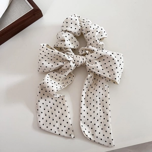 Dettaglio dell'elastico bianco a pois neri con lunghi nastri e fiocco in chiffon morbido