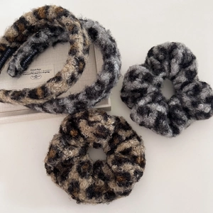 Close-up of fluffy leopard print headbands and scrunchies set with handmade label