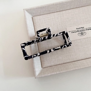 Minimalist black and white zebra pattern hair claw clip with gold metal spring on tray