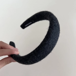 Vue détaillée de la texture en laine noire et de l'étiquette faite main du bandeau large