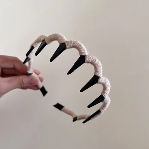 Detail of wool-wrapped wavy headband with non-slip teeth for voluminous hair styling