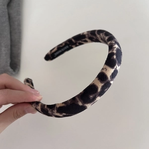Close-up of leopard print velvet headband with thick sponge and Hand Made woven label