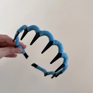 Detail of blue knitted yarn headband featuring sharp black anti-slip inner teeth