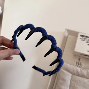 Detail of blue knitted wool yarn texture on wavy non-slip headband with comb teeth