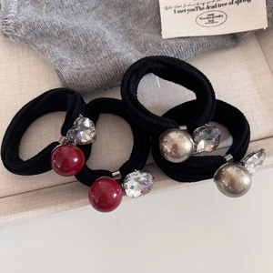 Détail d'élastiques à cheveux avec perles rouges et argentées et cristaux en cœur