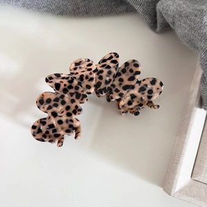 Close-up of leopard print acetate hair claw clip showing glossy finish and wavy texture