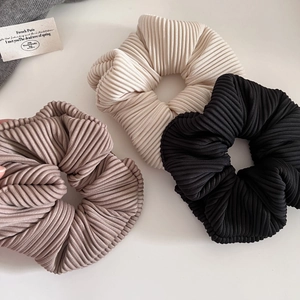 Elegant ribbed fabric hair scrunchies in cream, black, and brown colors for daily styling