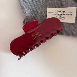 French vintage large burgundy acetate hair claw clip with golden lettering on white background