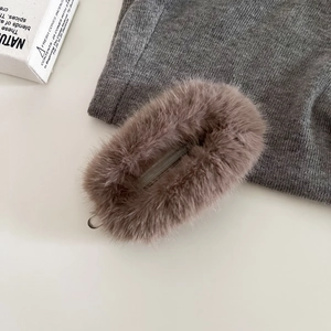 Gros plan sur la pince banane en fausse fourrure marron avec texture douce de luxe
