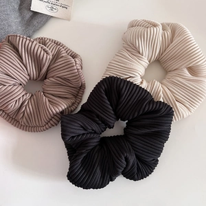 Detailed texture of ribbed hair scrunchies in black, beige and khaki fabric sets