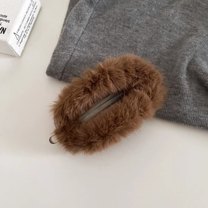Détail de la pince banane en peluche marron avec fourrure synthétique et structure acrylique