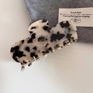 Detail of a large leopard print acetate hair claw clip with Barrette La France gold lettering