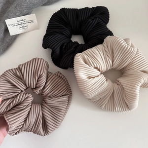 Three-piece set of ribbed scrunchies in black beige and mauve with pleated texture
