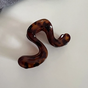Détail macro d'une pince à cheveux en S avec motif écaille de tortue et ressort durable