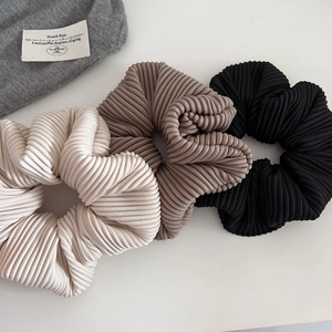 Close-up of ribbed fabric hair scrunchies in white, mocha coffee, and black colors