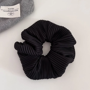 Macro shot of black pleated fabric scrunchie texture with stylish ribbed details