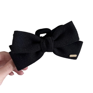 Elegant large black velvet bow hair claw clip with a luxury gold metal emblem