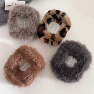 Detail of four faux fur hair clips in grey, brown, and leopard print with non-slip grips