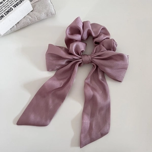 Dettaglio dell'elastico per capelli in raso con fiocco e lunghi nastri rosa