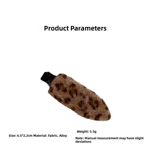 Detail view of a leopard print plush hair clip showing its 6.5x2.2cm size and soft texture