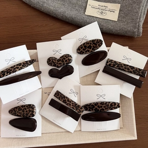 Dettaglio di varie mollette per capelli in resina leopardata e marrone scuro in diverse forme