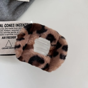 Close-up of leopard print plush hair claw clip showing soft faux fur and plastic teeth