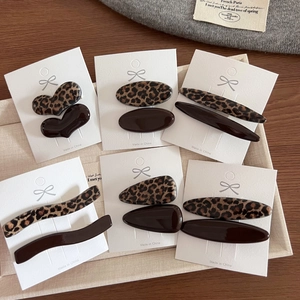 Dettaglio di fermagli per capelli maculati marroni a forma di cuore e ovali su carta